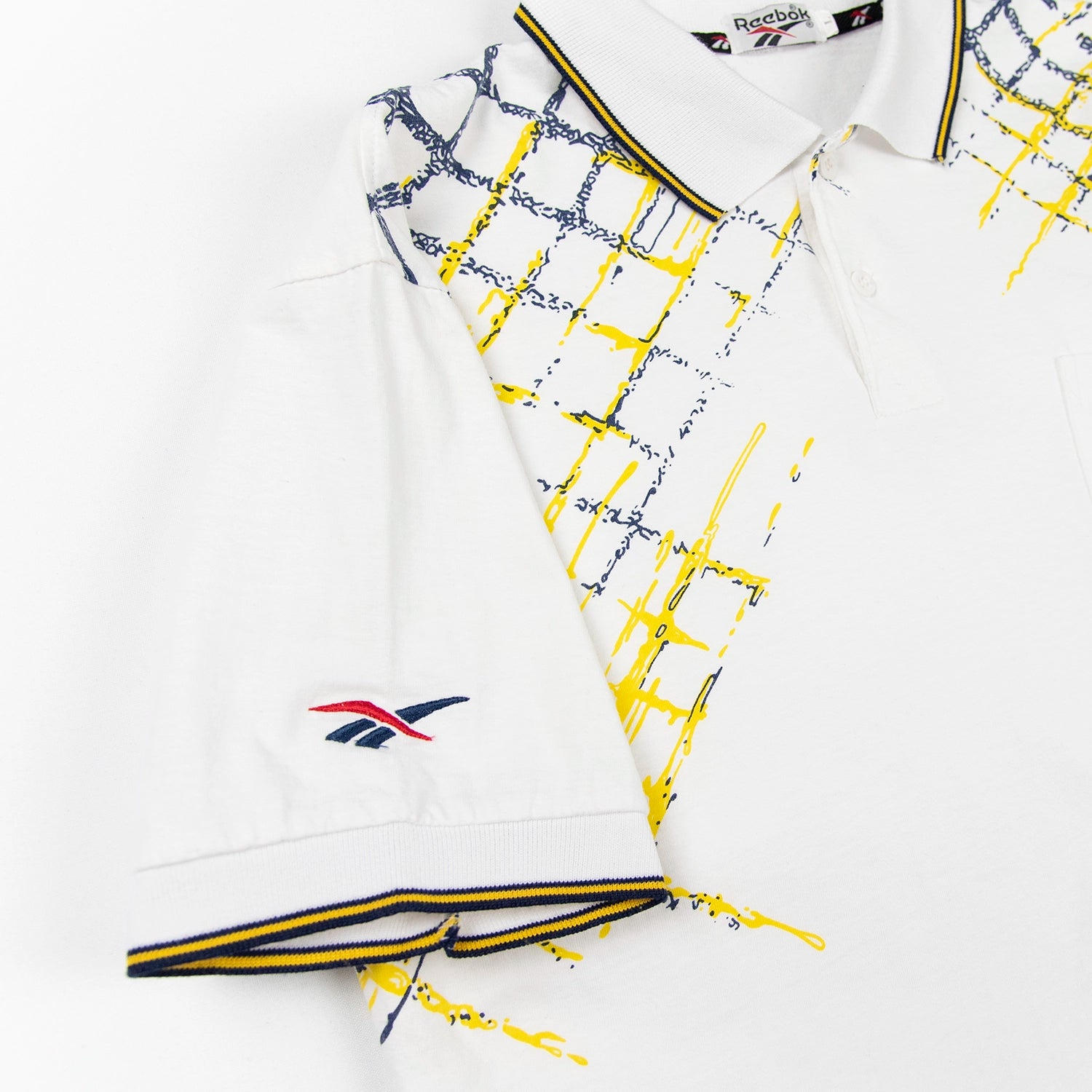 Dettaglio manica polo Reebok vintage con bordo blu e giallo