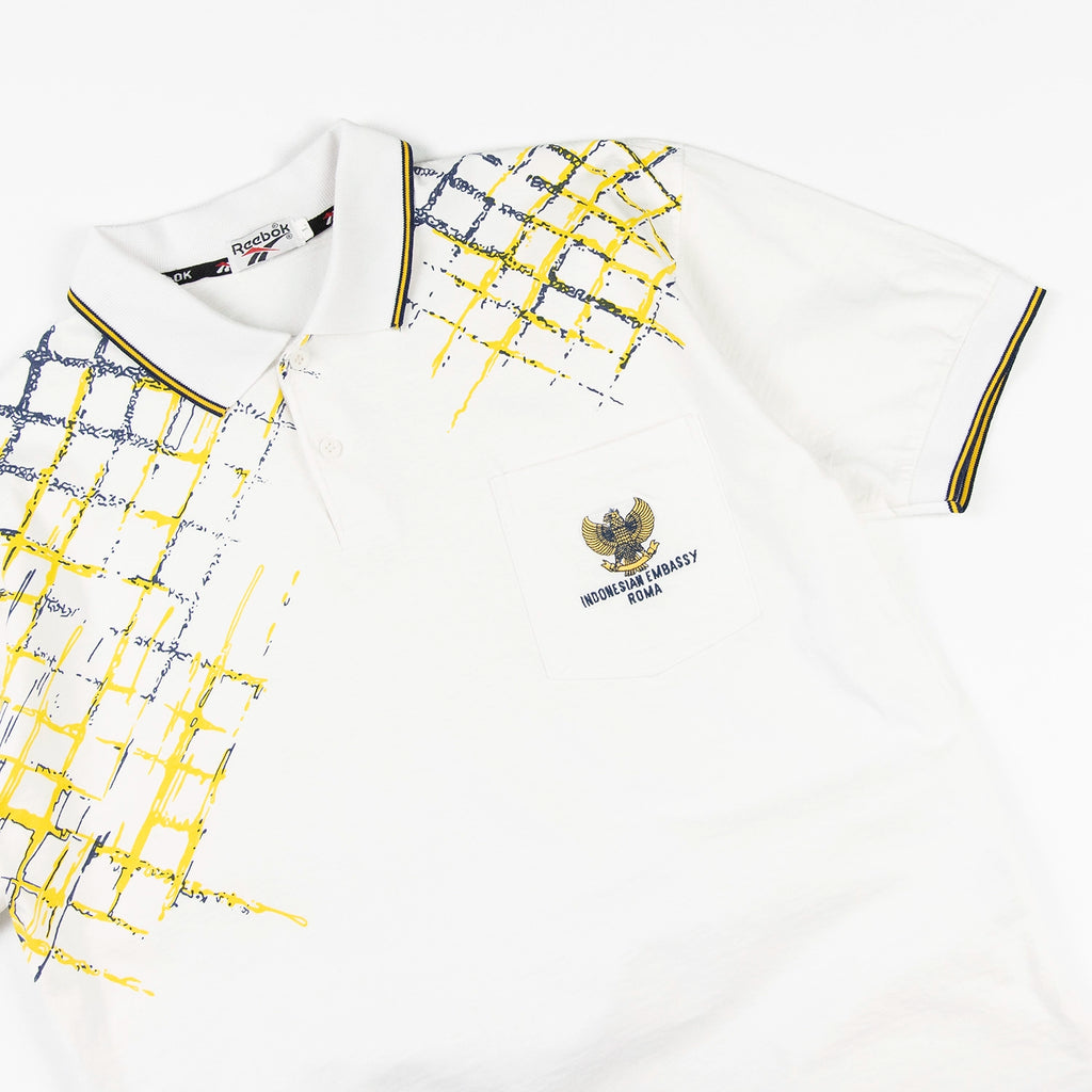 Polo vintage Reebok con grafica gialla e blu e logo Indonesian Embassy Roma sul petto